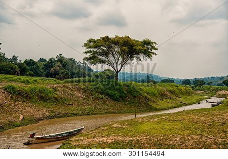 Boat On Amazon River In Boca De Valeria, Brazil. Amazon River Flow On Tropical Landscape On Cloudy S