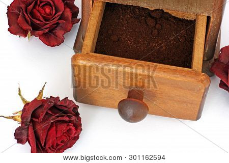 Manual Coffee Grinder With Roses On A White Background. Antiquary