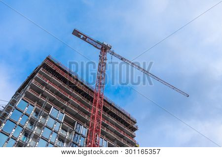 Unfinished Modern Office Building with Stationary Hoist Crane Construction Background.