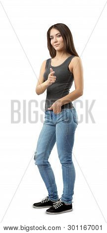Young Woman In Sleeveless Top And Jeans Standing In Half-turn With Left Hand In Pocket And Right Han