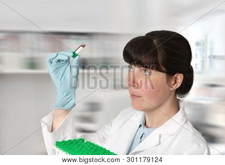 Female Young Doctor-intern, Tech Or A Scientist With Blood Test Tubes In Medical Or Research Facilit