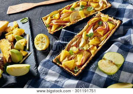 Delicious Pineapple And Apple Sweet Tart In Rectangular Tart Pans On A Concrete Table With Kitchen T