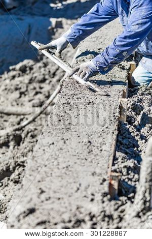 Pool Construction Worker Working With A Smoother Rod On Wet Concrete