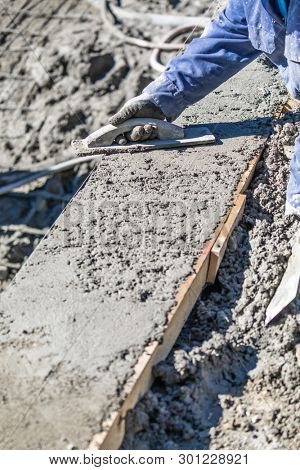 Pool Construction Worker Working With Wood Float On Wet Concrete