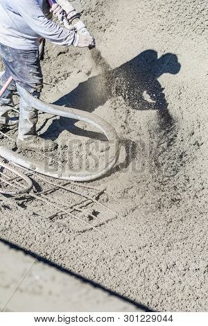 Pool Construction Worker Shooting Concrete, Shotcrete or Gunite Through Hose