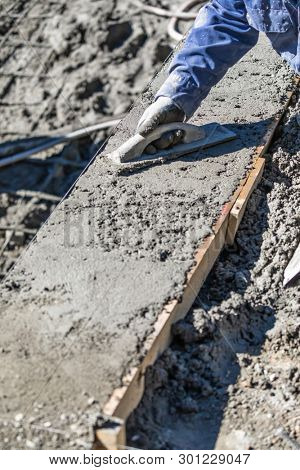 Pool Construction Worker Working With Wood Float On Wet Concrete