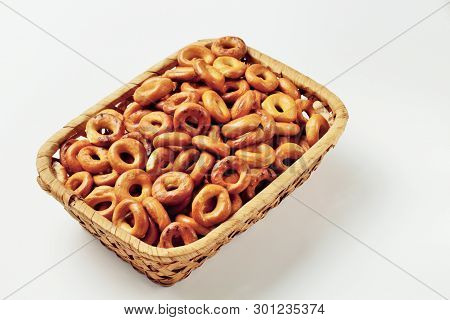 Bagels In A Wicker Bamboo Basket On A White Background, Place For Text. High Contrast, Top View.