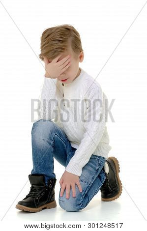 The Little Boy Holds His Head With His Hand. The Concept Of Illness, Chagrin. Isolated On White Back