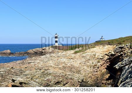 Island With Two Lighthouses And Violet Flowers. View From A Cliff, Sunny Day. Isla Pancha, Ribadeo, 