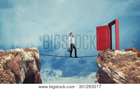 Surreal Challenge Overcome . Businessman Conquering Obstacle Balancing On Slackline Rope Above A Gap