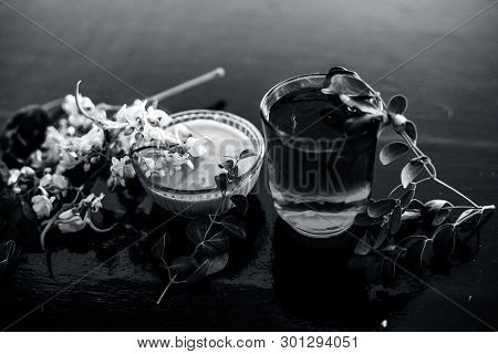 Bunch Of Flowers Of Drumstick On Wooden Surface Along With Its Extracted Water Or Tincture In A Glas