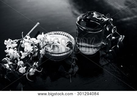 Bunch Of Flowers Of Drumstick On Wooden Surface Along With Its Extracted Water Or Tincture In A Glas