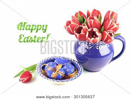 Bunch Of Red Tulips In Blue Ceramic Vase And Easter Eggs In Maching Plate On White Background, Text 