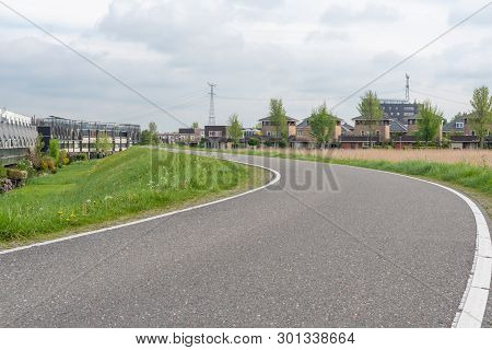 Empty Curved Road On A Dam In The Dutch Countryside, Capelle Aan Den Ijssel, Netherlands
