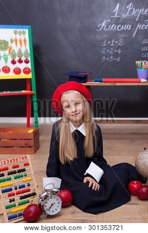 Back To School! A Little Girl Is Sitting In A Lesson. The Child Is Waiting For The End Of The Lesson