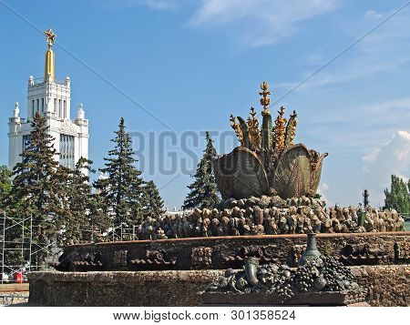 Moscow, Russia - June 21, 2008: The Stone Flower Fountain And The Gold Pavilion At The All-russia Ex