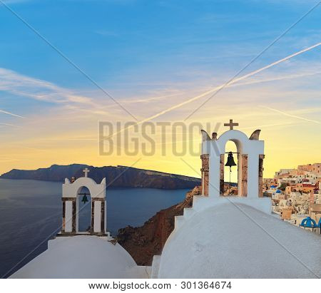 Sunset Over Local Church With Blue Cupola In Oia Village, Santorini Island, Greece