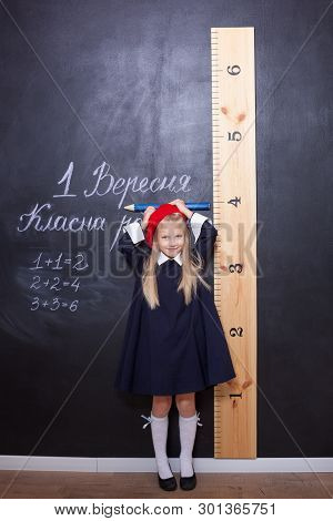 Back To School!schoolgirl Is At The Blackboard With A Ruler.schoolgirl Answers The Lesson.first Grad