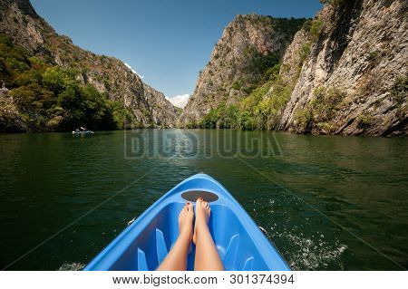 Kayaking Through River In Matka Canyon, Macedonia. Woman Legs In The Blue Kayak