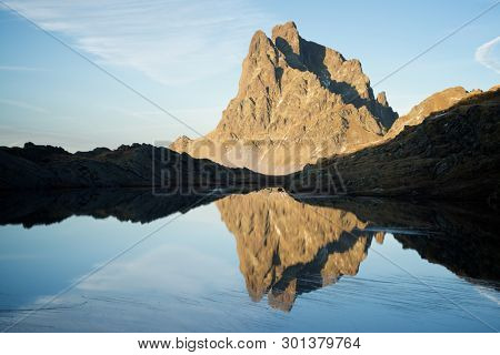 Midi Dossau Peak reflected in a lake. Ossau Valley, Pyrenees National Park, Pyrenees, France.