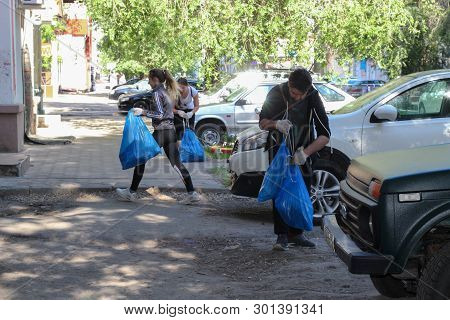 Plogging. Young People Run And Collect Garbage In Bags On The Streets Of Saratov, Russia, June 10, 2