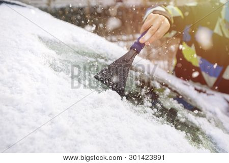 Scraping Ice From The Car Window In Winter Time
