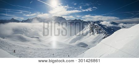 Panoramic View Down Snow Covered Valley In Alpine Mountain Range With Frost And Sunlight Sundog In A