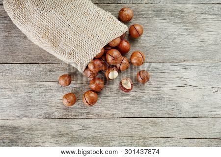 Macadamia Nut On A Wooden Table In A Bag, Closeup, Top View