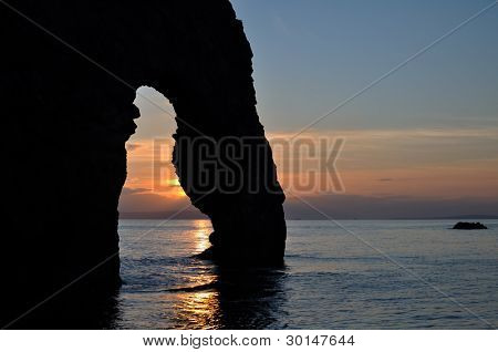 Pôr do sol na porta Durdle Lulworth Dorset England.