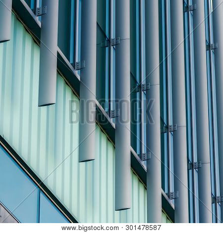 Clear Square Exterior Of A Modern Building With Vertical Sunshades Outside The Glass Windows