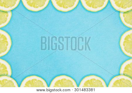 Border Of Lemon Slices On A Blue Background. Flat Lay Summer Concept.