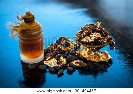 Raw Organic Amli Or Tamarind Or Imli In A Clay Bowl On Wooden Surface With Its Extracted Herbal Esse