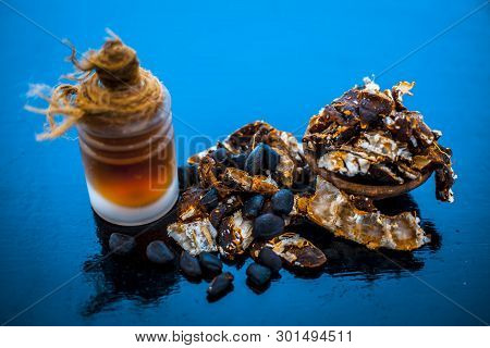 Raw Organic Amli Or Tamarind Or Imli In A Clay Bowl On Wooden Surface With Its Extracted Herbal Esse
