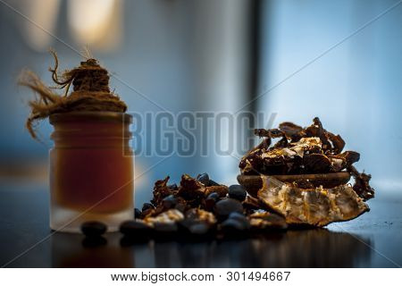 Raw Organic Amli Or Tamarind Or Imli In A Clay Bowl On Wooden Surface With Its Extracted Herbal Esse