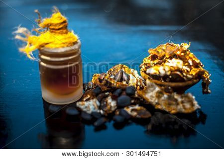 Raw Organic Amli Or Tamarind Or Imli In A Clay Bowl On Wooden Surface With Its Extracted Herbal Esse
