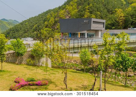 Muju,south Korea; May 1, 2019: Landscape Of Lawn And Dry Riverbed Running Under Bridge With Taewondo