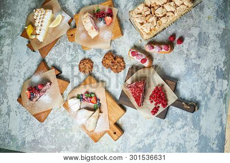 Assorted Sweet Desserts. Top View. Gray Textured Background. Beautiful Serving Dishes. Dessert. Food