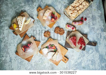 Assorted Sweet Desserts. Top View. Gray Textured Background. Beautiful Serving Dishes. Dessert. Food