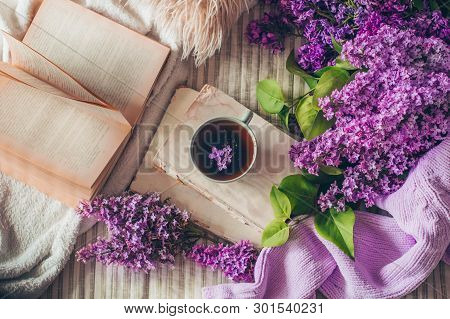 Still Life Details In Home Interior Of Living Room. Sweaters And Cup Of Tea With Lilac Flowers And S