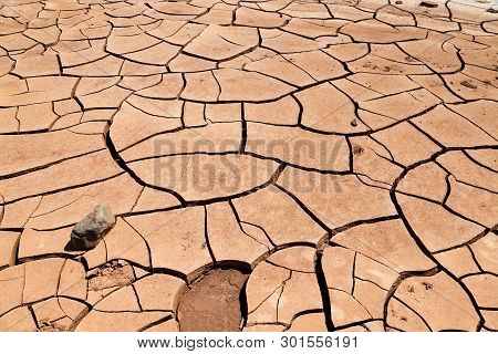Cracked Clay Soil In Front Of The Flaming Mountains In China, Xinjiang Province. Located In The Turp