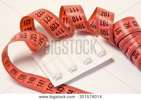 Laxatives Rectal Suppositories In Package And Measuring Tape Around. Using Laxatives Medicines For W