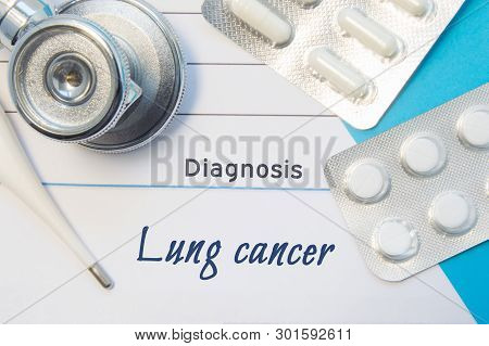 Diagnosis Lung Cancer. Doctors Stethoscope, Electronic Thermometer And Two Blisters Of Pills Lying N