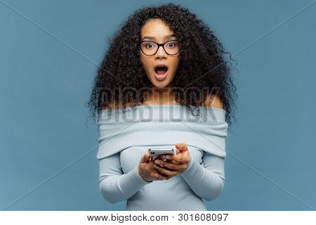 Impressed Amazed Dark Skinned Female Has Afro Haircut, Uses Cell Phone, Reads Post Online, Shocked B
