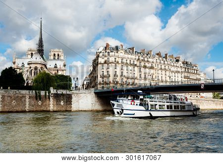 Paris, A Passenger Boat On The River Goes Around Ile De La Cite Passing Notre Dam