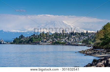 Majestic Mount Rainier Towers Over The Ruston Shoreline Near Tacoma, Washington.