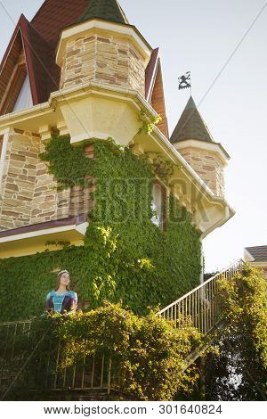 Girl Animator Dressed As A Medieval Princess On The Background Of The Castle In A Beautiful Park