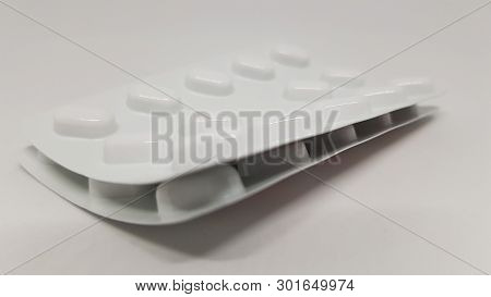 2 Strips Of Sealed Tablets Stacked On Top Of Each Other.