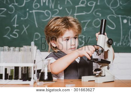 Happy Smiling Pupil Drawing At The Desk. Schoolchild. It Was A Little Chemistry Experiment. Chemistr