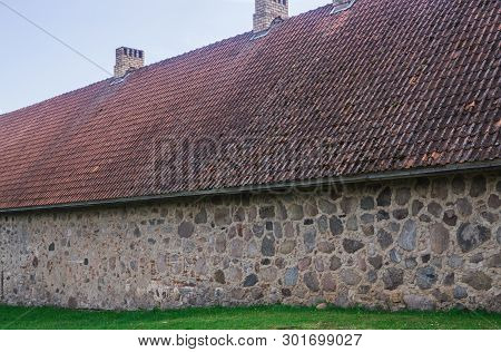 The Masonry Wall Of The Old Manor Shlokenbek From Stones In Latvia.old Barn.