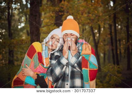People Sneezing In Handkerchief Autumn Outdoor. People Got Flu, Having Runny Nose. A Young Couple Du